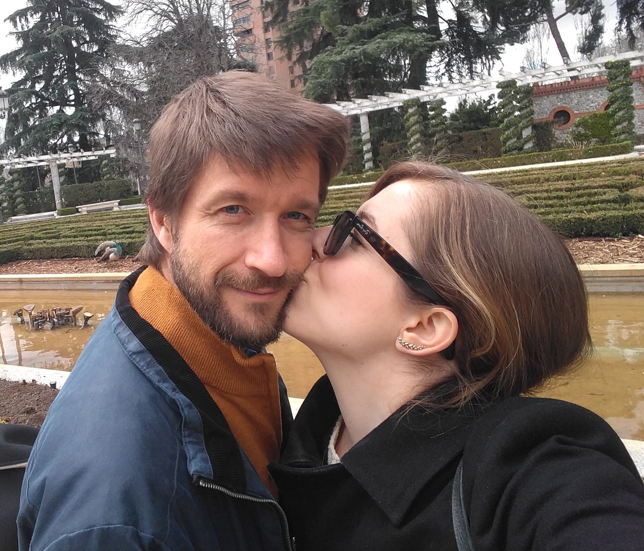 Edu mira a cámara mientras Cris le da un beso en la mejilla